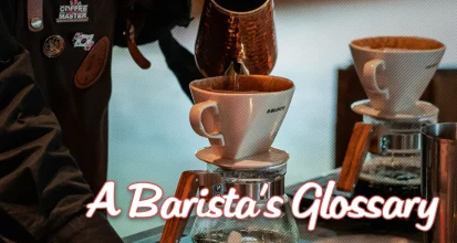A barista pulling an espresso shot from a commercial machine illustrating barista terminology and workflow