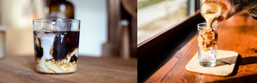 Two iced coffee drinks: cream swirling into dark coffee over ice in a tumbler, and espresso being poured over ice in a tall glass by a window
