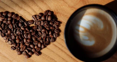 Roasted coffee beans and a world map illustrating coffee production and consumption facts