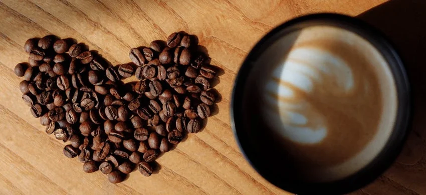 Roasted coffee beans and a world map illustrating coffee production and consumption facts