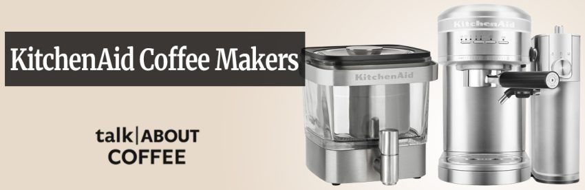 A KitchenAid drip coffee maker in classic Empire Red color on a light wood kitchen counter beside a matching ceramic mug