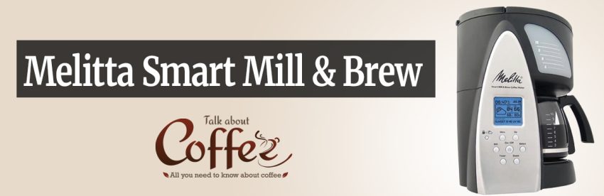 Melitta Smart Mill & Brew coffee maker in black and silver, with an LCD screen showing time, temperature and sunset data beside a glass carafe