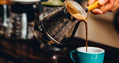 Cup of black coffee beside a blood pressure cuff illustrating coffee and hypertension research