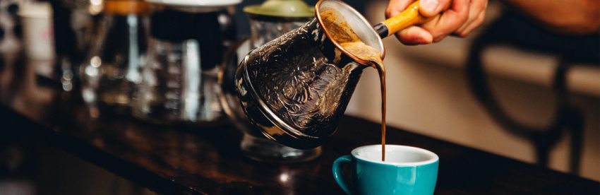 Cup of black coffee beside a blood pressure cuff illustrating coffee and hypertension research