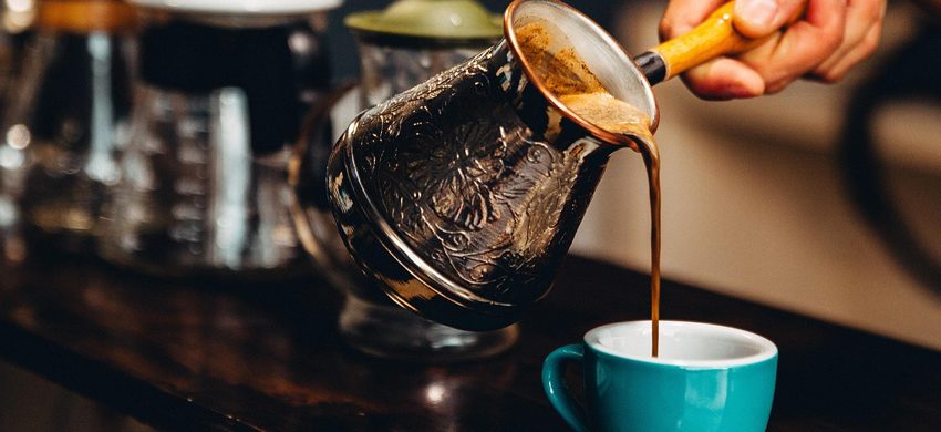 Cup of black coffee beside a blood pressure cuff illustrating coffee and hypertension research