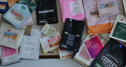 A colorful pinboard covered in coffee bags from many different roasters and brands, each with distinct packaging design