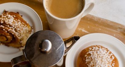 Cinnamon buns and a cup of coffee served together on a tray for fika