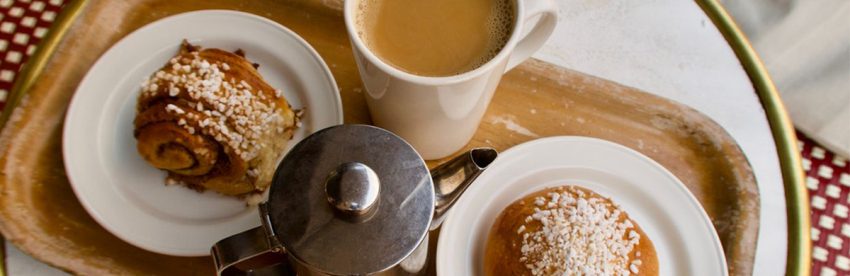 Cinnamon buns and a cup of coffee served together on a tray for fika