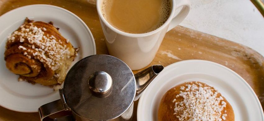 Cinnamon buns and a cup of coffee served together on a tray for fika