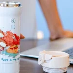 Insulated travel mug on a desk as a coffee gift idea for coworkers and clients