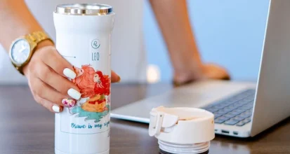 Insulated travel mug on a desk as a coffee gift idea for coworkers and clients