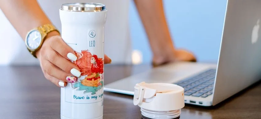 Insulated travel mug on a desk as a coffee gift idea for coworkers and clients