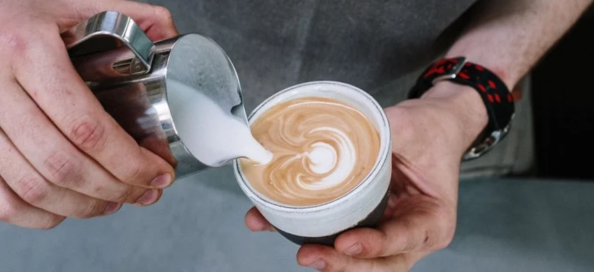 ilk being poured into a cup of coffee
